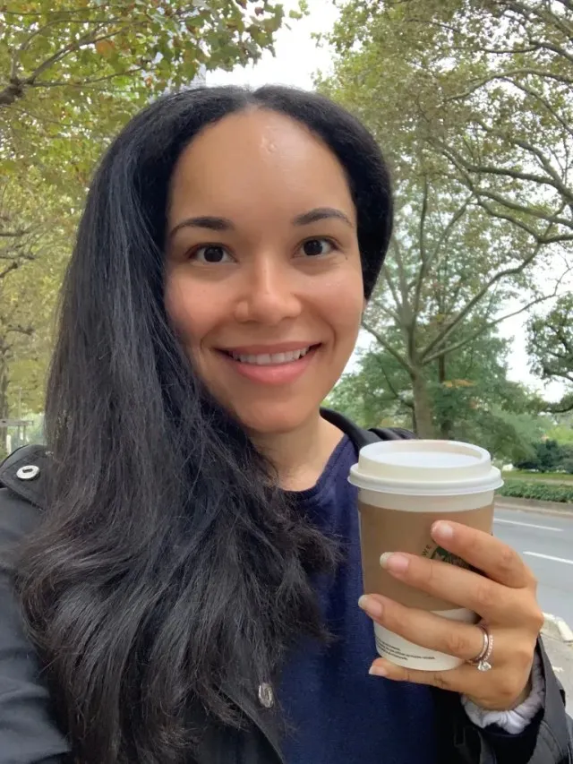A woman in her early 30s taking a selfie while enjoying a solo walk and coffee. The photos shows a happy mom having some alone time.