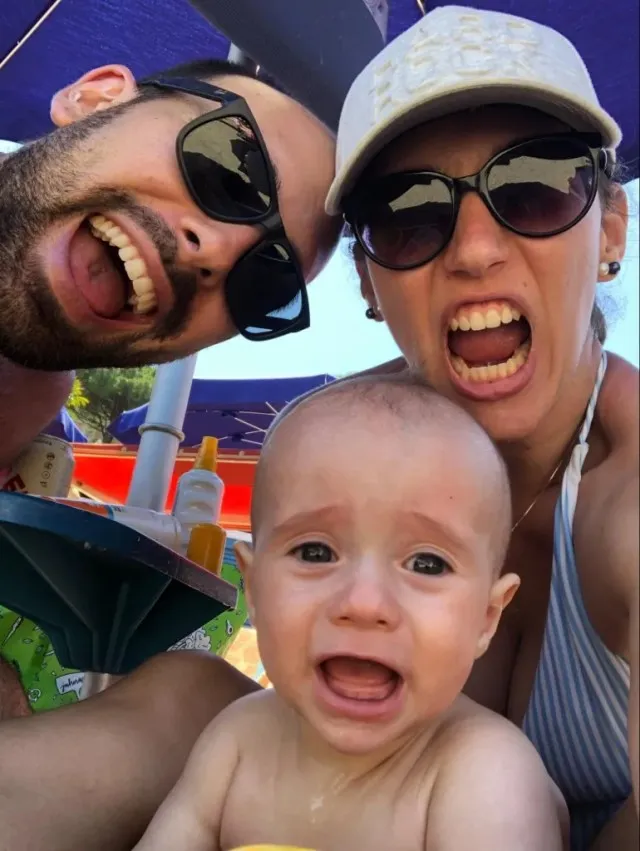 Man, woman and child at the beach in Italy. All three opened their mouths wide from excitement.
